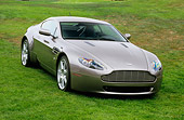 AUT 06 RK0072 03
2006 Aston Martin DB7 Vantage Gray 3/4 Front View On Grass Aston Martin In Background