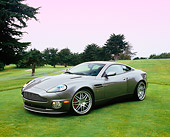 AUT 06 RK0079 05
2005 Aston Martin Vanquish Gray 3/4 Side View On Grass By Trees
