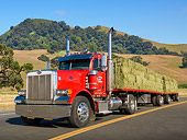 AUT 07 RK0119 01
2006 Peterbilt Semi Red 3/4 Front View On Road By Hills