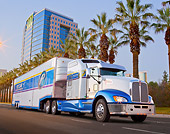 AUT 07 RK0185 01
2012 Kenworth T660 White And Blue 3/4 Front View On Road By Palm Trees And Building
