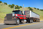 AUT 07 RK0281 01
1989 Ford 9000 Red And Black With Trailer 3/4 Front View On Road By Hills