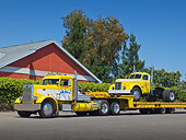 AUT 07 RK0370 01
1958 Peterbilt 281 With 1948 GMC 900 Series Yellow And White On Trailer 3/4 Side View On Pavement By Brick Building
