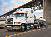 AUT 07 RK0382 01
1999 Mack CH613 White With American Flag 3/4 Front View On Road Under Bridge