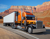 AUT 07 RK0405 01
2000 Freightliner Orange With Graphics 3/4 Front View On Road By Red Rock