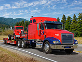 AUT 07 RK0408 01
2004 International Eagle Red And Blue 3/4 Front View On Road By Evergreen Trees
