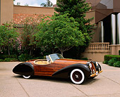 AUT 09 RK0400 02
The Dolphin Wooden Roadster Front 3/4 View On Pavement By Building And Trees