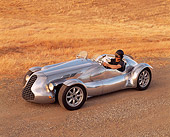 AUT 09 RK0425 01
Special Six Roadster Silver Side 3/4 View On Dirt With Driver By Dry Grass