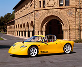 AUT 09 RK0449 06
AC Propulsion tZero Electric Sports Car Prototype Yellow Side 3/4 View On Pavement By Building
