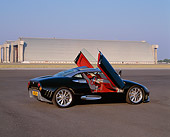 AUT 09 RK0460 01
Spyker C8 Laviolette Coupe Black 3/4 Rear View Doors Open On Pavement By Hangar