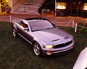 AUT 09 RK0616 03
2005 Ford Mustang Concept Coupe Silver 3/4 Front View On Grass By Building