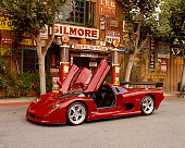 AUT 09 RK0655 02
2003 Mosler MT900S Prototype Rosa Barchetta 3/4 Front View On Pavement By Building