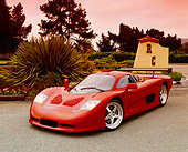 AUT 09 RK0667 08
2003 Mosler MT900S Prototype Rosa Barchetta Front 3/4 View On Pavement By Bushes Filtered