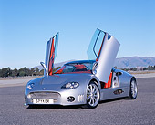 AUT 09 RK0840 02
2006 Spyker C8 Double 12 S Silver 3/4 Front View Doors Open On Pavement Blue Sky