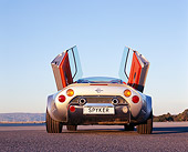 AUT 09 RK0853 01
2006 Spyker C8 Double 12 S Silver Low Rear View Doors Open On Pavement Blue Sky