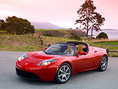 AUT 09 RK0882 01
Tesla Roadster Electric Car Red 3/4 Front View On Pavement By Grass And Trees