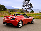 AUT 09 RK0883 01
Tesla Roadster Electric Car Red 3/4 Rear View On Pavement By Grass And Trees
