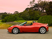 AUT 09 RK0885 01
Tesla Roadster Electric Car Red Profile View On Pavement By Grass And Trees