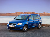 AUT 09 RK1042 01
Volkswagen Touran HyMotion Prototype Blue 3/4 Front View On Pavement By Water Hills Sky