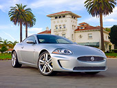 AUT 12 BK0001 01
2011 Jaguar XKR Coupe Silver 3/4 Front View On Pavement By Palm Trees And Building