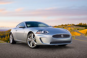AUT 12 BK0002 01
2011 Jaguar XKR Coupe Silver 3/4 Front View On Road By Hillside