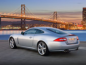 AUT 12 BK0005 01
2011 Jaguar XKR Coupe Silver 3/4 Rear View On Pavement By San Francisco Bay Bridge At Dusk