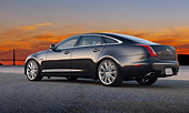 AUT 12 BK0010 01
2012 Jaguar XJF Black 3/4 Rear View On Pavement By Water And Bridge At Sunset