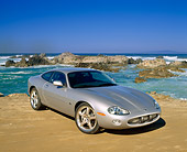 AUT 12 RK0126 07
2001 Jaguar XKR Silverstone Coupe 3/4 Front View On Sand By Ocean And Rocks Blue Sky