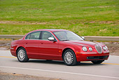 AUT 12 RK0220 01
2006 Jaguar S-Type Red 3/4 Side View On Road By Grass Hills