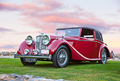 AUT 12 RK0367 01
1948 Jaguar Mark IV Drophead Coupe Red 3/4 Front View On Grass At Dusk