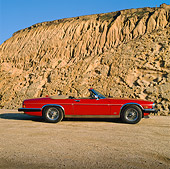 AUT 12 RK0032 01
1988 Red Jaguar XJ5 Side View Rock Mountain Background Blue Sky