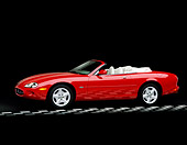 AUT 12 RK0061 02
1999 Jaguar XK8 Convertible Phoenix Red 3/4 Side View On Checkerboard Line Parking Lights On Studio