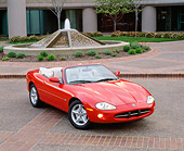 AUT 12 RK0066 01
1999 Jaguar XK8 Convertible Phoenix Red Overhead 3/4 Front On Pavement Headlights On By Fountain