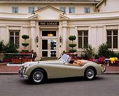 AUT 12 RK0072 01
1955 Jaguar XK140 SE Convertible Light Green 3/4 Side View On Pavement By Building