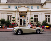 AUT 12 RK0072 03
1955 Jaguar XK140 SE Convertible Light Green 3/4 Side View On Pavement By Building