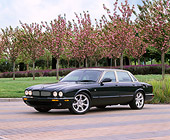 AUT 12 RK0133 02
2001 Jaguar XK8 CNV Green Side 3/4 View On Pavement By Pink Flower Trees