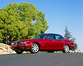 AUT 12 RK0176 03
2004 Jaguar XJ Burgundy 3/4 Front View Low Angle On Pavement Hill Trees Blue Sky