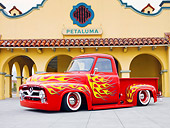 AUT 14 BK0042 01
1954 Ford F-100 Pickup Truck Hot Rod Red With Flames 3/4 Front View On Pavement By Building