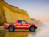 AUT 14 BK0058 01
2011 Ford F-150 SVT Raptor Pickup Truck Red Profile View On Beach By Cliffs