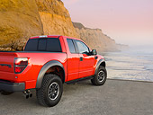 AUT 14 BK0061 01
2011 Ford F-150 SVT Raptor Pickup Truck Red 3/4 Rear View On Beach By Cliffs