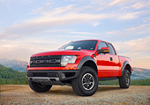 AUT 14 BK0063 01
2011 Ford F-150 SVT Raptor Pickup Truck Red 3/4 Front View On Dirt By Pine Forest And Mountains