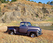 AUT 14 RK0135 02
1954 Chevy 3100 Series 1/2 Ton Truck Gray 3/4 Side View On Dry Grass By Water And Rocky Hill