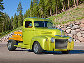 AUT 14 RK1697 01
1947 Ford Pickup Flatbed Lime Gold 3/4 Front View On Pavement By Pine Trees