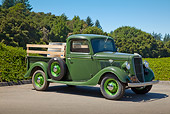 AUT 14 RK1705 01
1935 Ford Pickup Green With Barrels 3/4 Side View On Pavement By Trees