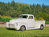 AUT 14 RK1755 01
1951 GMC Pickup Gray With Ghost Flames 3/4 Side View On Grass By Trees