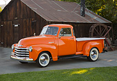 AUT 14 RK1789 01
1953 Chevrolet Pickup Orange 3/4 Side View On Pavement By Wooden Shed