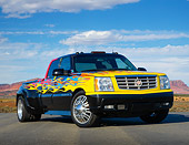 AUT 14 RK1801 01
2006 Cadillac Escalade XXL Black With Yellow, Blue And Red Flames 3/4 Front View On Pavement In Desert