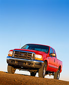 AUT 14 RK0044 05
1999 Ford F250 XLT Super Duty Red 4x4 Triton V10 Quad Door Low 3/4 Front View On Dirt Blue Sky