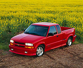 AUT 14 RK0072 01
1999 Chevrolet S-10 Extreme Pick Up Truck Red 3/4 Front View By Yellow Flower Field