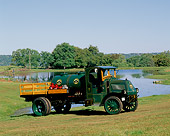 AUT 14 RK0091 03
1919 Mack AC Stake Truck Green 3/4 Front View On Grass Hill By Water
