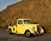 AUT 14 RK0097 08
1936 Ford 327 Truck Yellow Side 3/4 Front View On Pavement Against Rock